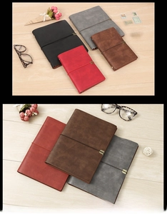 Detail view of vintage leather notebooks with elastic bands and metal buckles in multiple colors