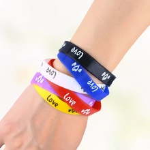Detail of colorful silicone sports wristbands with Love print worn on wrist