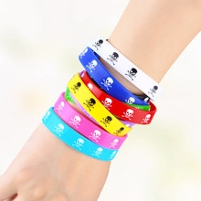 Detail showing seven colorful silicone wristbands with vibrant skull and crossbones patterns