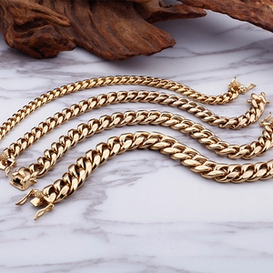 Polished gold Cuban link bracelets for women in four varied widths on marble surface