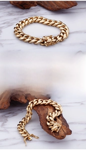 Detailed view of golden Cuban link bracelet with polished metal finish and press buckle