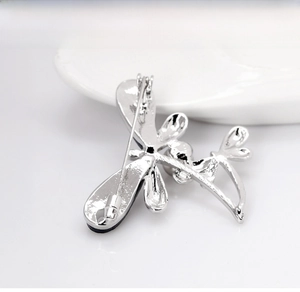 Detailed back view of a silver dragonfly brooch showing the secure safety pin clasp