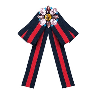 Detail view of navy and red striped grosgrain ribbon bow brooch with crystal gemstone flower