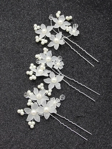U-shaped hair pins with matte white flowers and pearls on a black glitter background
