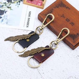 Vintage leather keychain with bronze feather pendant in black and reddish brown colors