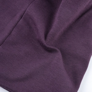Close-up of purple knitted fabric showing fine texture and star-like rhinestone details