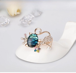 Détail de la broche chat en alliage avec nacre d'abalone, strass blancs et perle