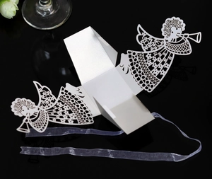 Detailed laser-cut angel candy box in white paper with a purple ribbon and reflection