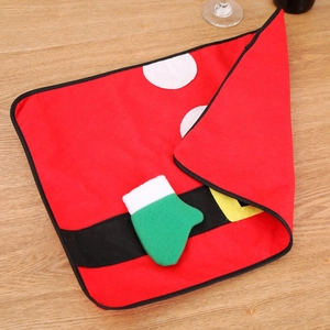 Close-up of Santa belt buckle placemat with green sock detail on light wood background