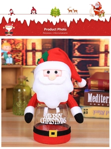 Detail of Santa Claus candy jar with clear glass body and festive felt belt decoration