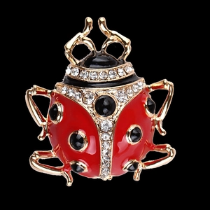 Red enamel ladybug brooch with black gemstones and sparkling crystals on black background