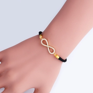 Bracciale infinito regolabile in metallo dorato con zirconi bianchi e cordino nero