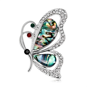 Detailed close-up of a silver butterfly brooch with shell inlay and colorful rhinestones