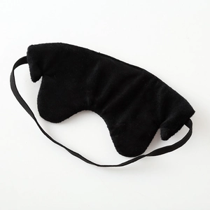 Detail showing the plush black sleep mask texture and elastic headband for comfort