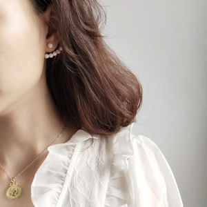 Detail of 925 sterling silver pearl fan stud earrings and gold coin pendant necklace