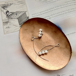 Elegant 925 silver pearl drop earrings displayed on a vintage book and bronze tray