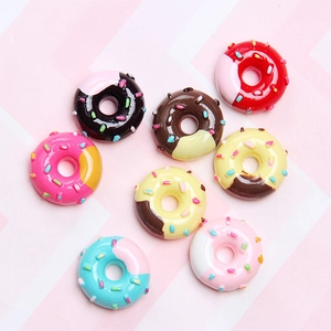 Flat lay of colorful miniature resin donuts with sprinkles for DIY craft accessories