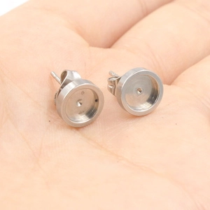Pair of round stainless steel stud earring bases for DIY jewelry making on palm