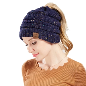 Detail of dark blue ponytail beanie featuring colorful yarn and branded C.C leather tag