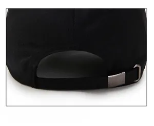 Détail de la boucle métallique réglable sur une casquette en coton noir de qualité
