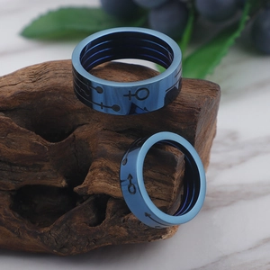 Classic blue titanium steel couple rings with male and female symbols on dark wood background