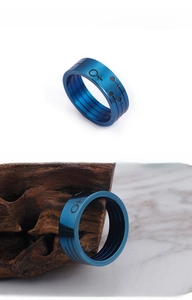 Detail of blue titanium steel ring featuring black engraved geometric symbols on band