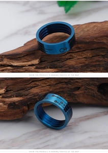 Detail of blue titanium steel ring featuring black nautical symbols and pirate map motifs