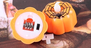 Detail of Halloween pumpkin LEDs showing battery compartment and spider web patterns