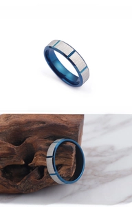 Macro view of stainless steel ring with silver brushed finish and blue grooved details