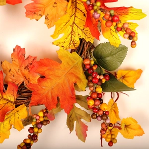 Autumn wreath with colorful maple leaves and berries on a natural woven rattan base