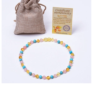 Collier en ambre pour bébé avec certificat et pochette en lin sur fond blanc épuré