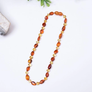Collier pour bébé en ambre de la Baltique avec perles irrégulières sur fond blanc