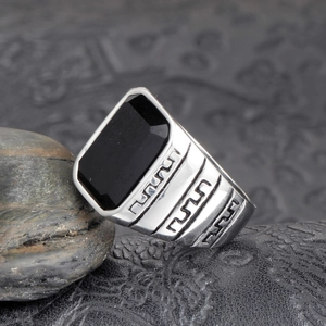 Détail macro d'une bague pour homme en acier argenté avec pierre noire rectangulaire