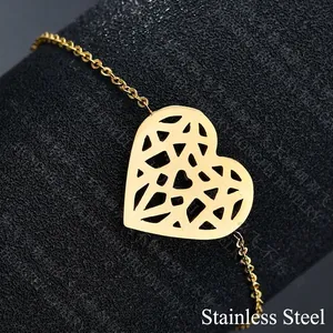 Golden chain bracelet with a geometric hollow heart pendant on a textured display