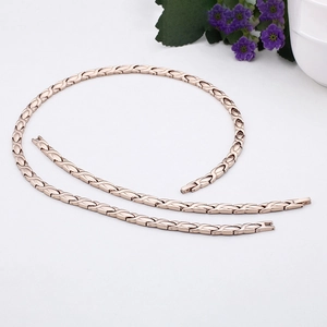 Rose gold titanium magnetic necklace and bracelet set displayed with purple flowers