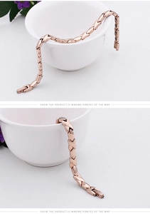 Macro shot of rose gold X-link magnetic therapy bracelet hanging on a white porcelain cup