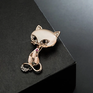 Elegant cat brooch in rose gold with opal stones and crystals on a black gift box