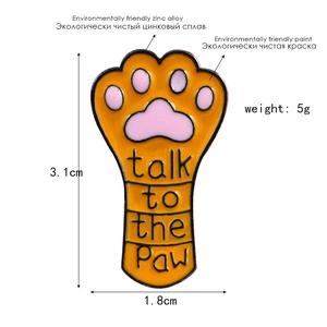 Detailed view of orange cat paw enamel pin with Talk to the Paw text and size markings