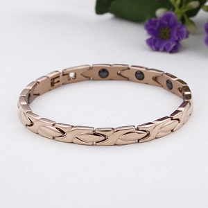 Bracciale magnetico in acciaio oro rosa con magneti neri su sfondo bianco pulito