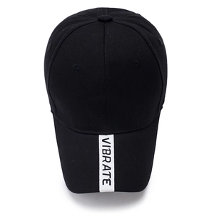 Classic black cotton baseball cap with white VIBRATE letter ribbon on the brim