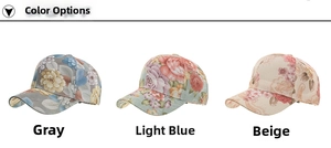 Detailed view of floral print baseball caps in grey, light blue, and beige colors