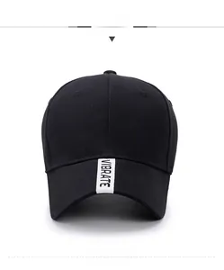Detailed shot of a black cotton baseball cap with white VIBRATE strap on the brim