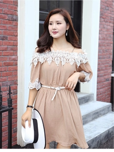 Close-up of white lace detailing on a beige off-shoulder dress with thin leather belt
