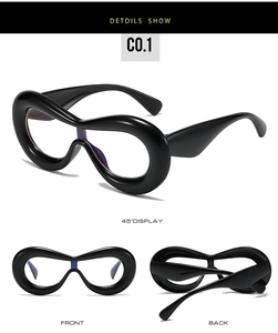 Detail view showing oversized black chunky frame glasses with wide streamlined temples