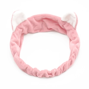Detailed view of the pink plush headband featuring cute white cat ear design and soft texture