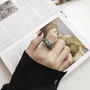 Close-up of vintage multi-layer sterling silver wrap ring on finger with artistic backdrop