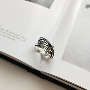 Detail of vintage multilayer 925 silver ring with black stones on an artistic book