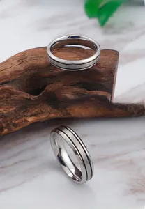 Detail of brushed stainless steel ring featuring dual black grooved industrial design