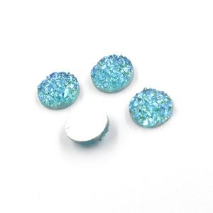 Macro shot of 8mm blue druzy resin cabs showing textured sparkle and flat white backings