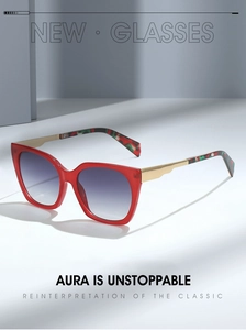 Detailed view of red cat-eye sunglasses with gold metal and camouflage patterned temples